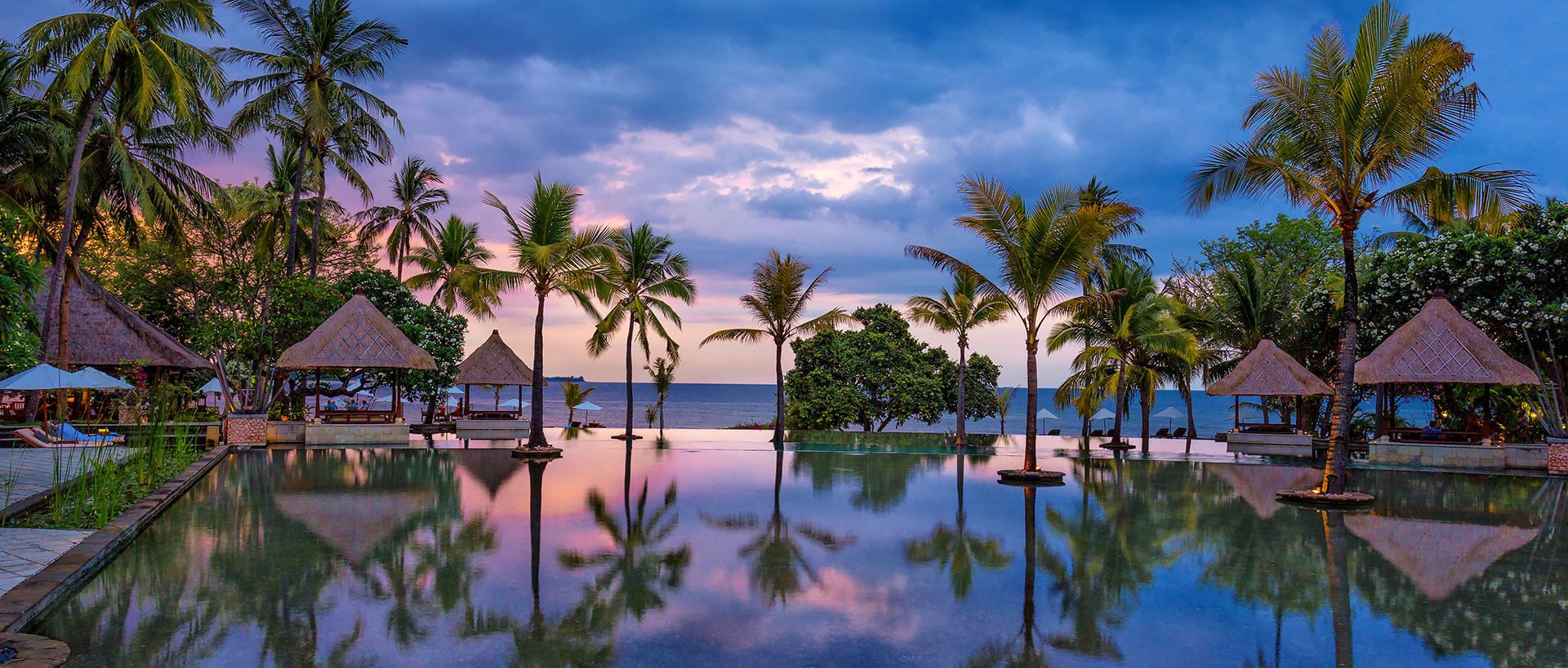 Swimming pool and palm tree views at The Oberoi Lombok
