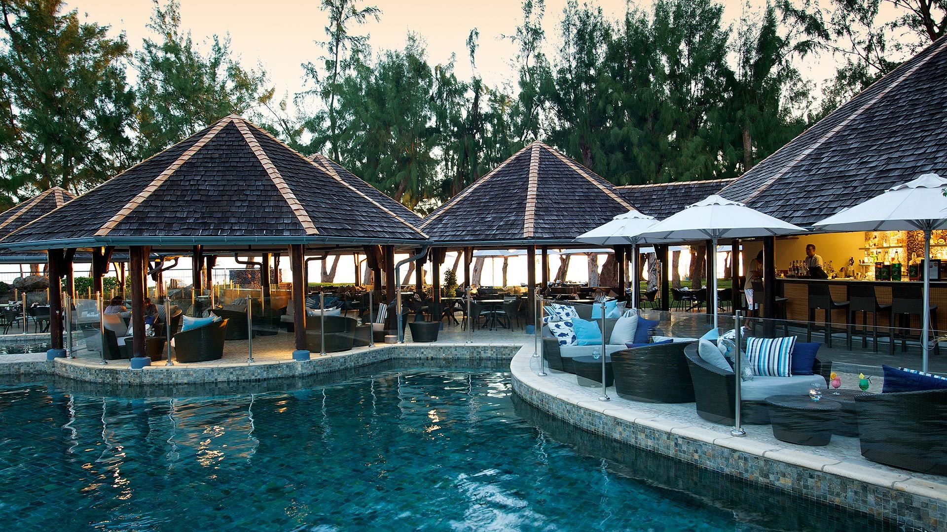 Shady sunloungers look out over the pristine white beach and blue sea at LUX* Saint Gilles Reunion