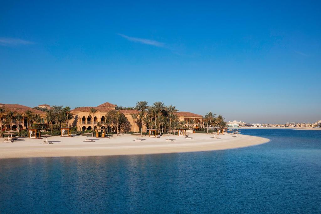 A perfectly manicured beach rolls away from the shady palm trees of One & Only The Palm, Dubai